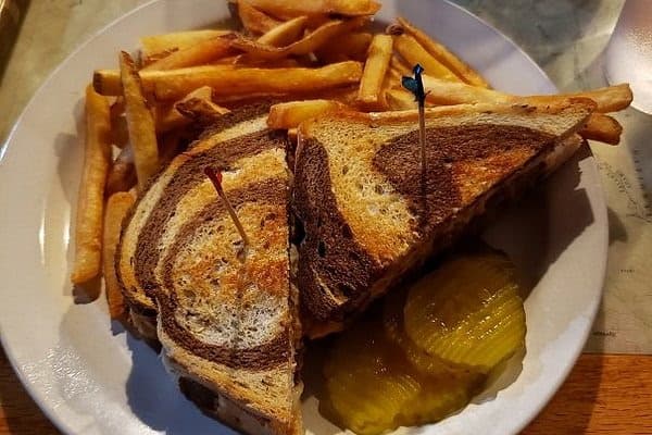 Marble rye sandwich with fries and pickles